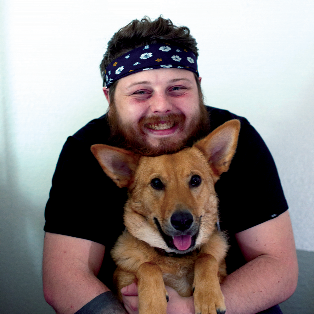 Owner of Jerapis Designs, Jeremy Piske, holding his dog saga.